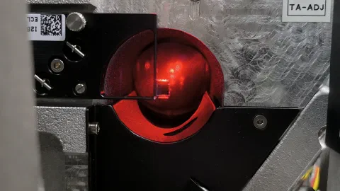 Sample glowing red inside an experimental characterization setup